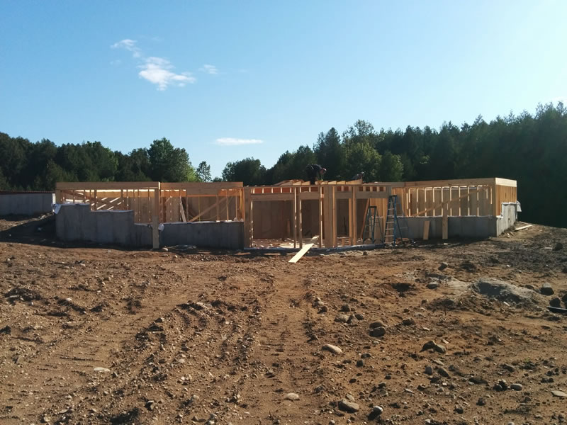 Framing rising from a new foundation on an excavated, graded lot, an A&R build in Oro-Medonte in 2018