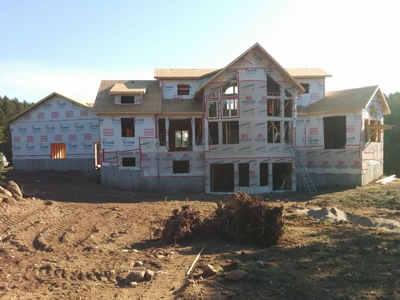 An A&R home framed, sheathed and wrapped in house wrap, with the roof on and the window openings still empty
