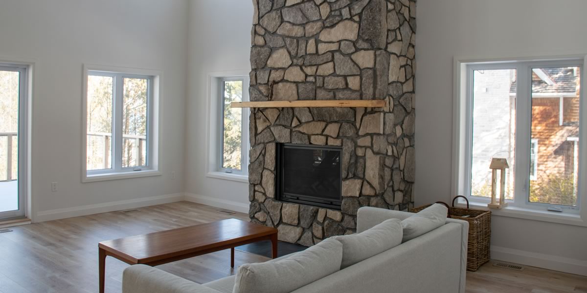 Great room with a floor-to-ceiling stone fireplace